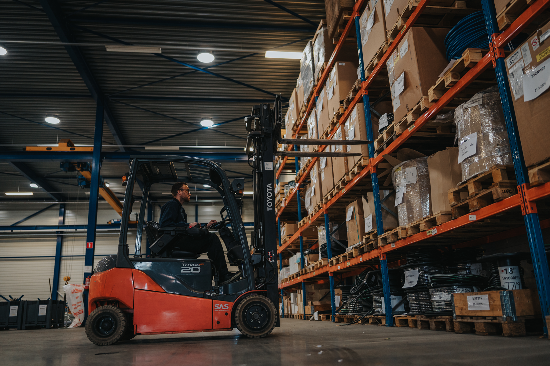 Medewerker van Leeuwtechniek verwerkt slangvoorraad in het magazijn
