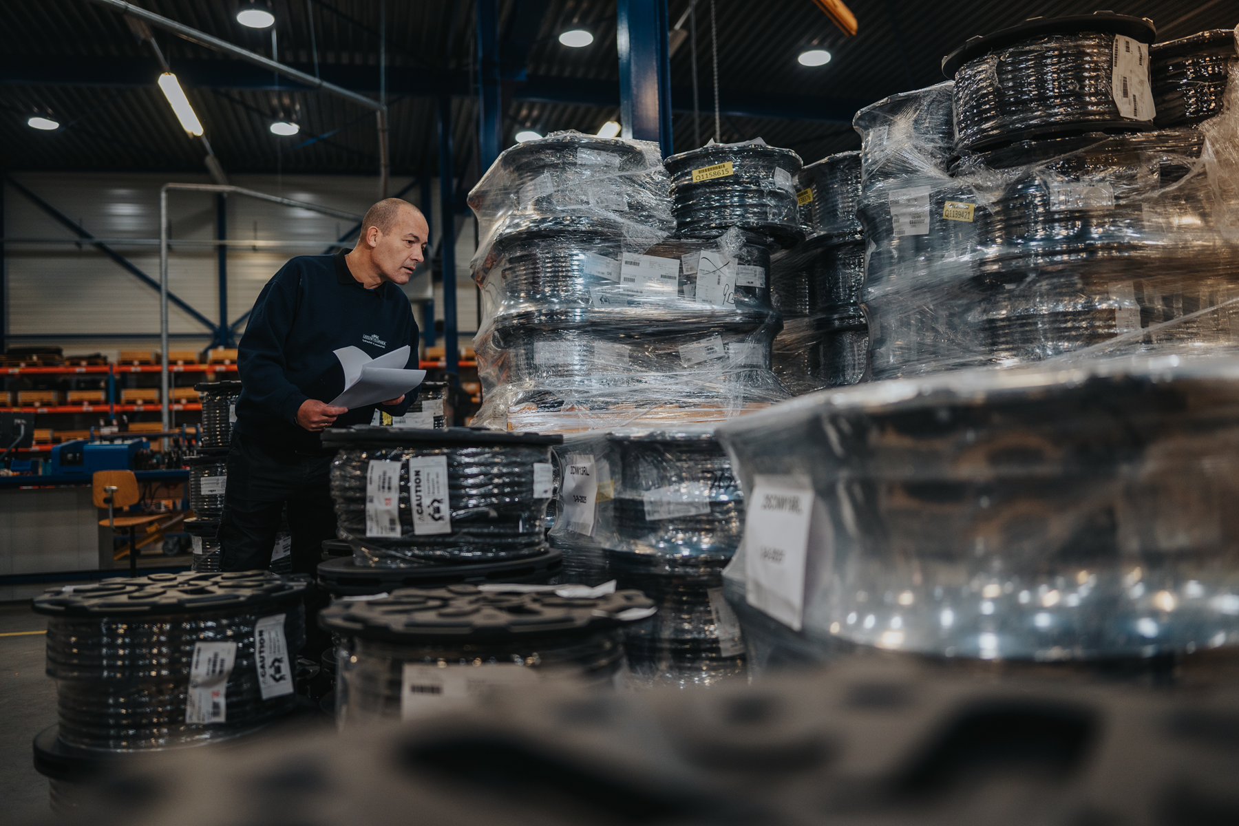 Medewerker van Leeuwtechniek bij rollen technische slang die voor orders zijn klaargezet